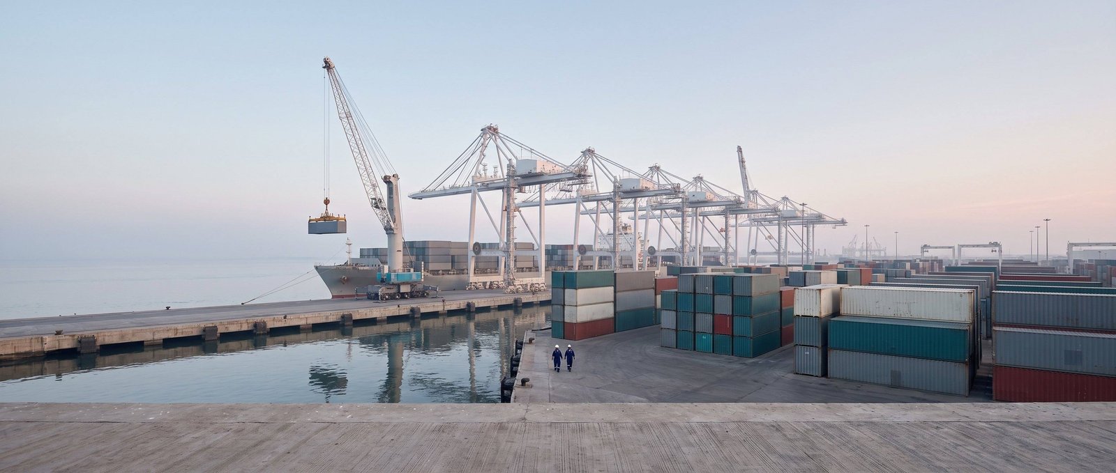 Container cranes and stacked containers at a port terminal at first light